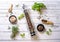 Pepper mill with different peppers in bowl with himalayan salt and fresh rosemary and basil on the wooden background