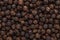 Peppercorn background. Dry black pepper seeds. Top view. Flat design. Macro spice background