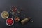 Peppercorns and a bronze pepper mill on black background, top view, copy space