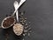 Peppercorns in rustic silver spoons on dark background