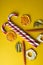 Peppermint candy canes with dried fruits on a yellow background