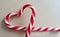 Peppermint Candy Canes in Heart Shape on textile background