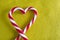 Peppermint Candy Canes in Heart Shape on textile background