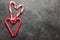 Peppermint Candy Canes in Heart Shapes on black concrete background. Christmas background. top view with copy space