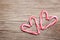 Peppermint Candy Canes in Heart Shapes on wooden background