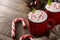 Peppermint coffee mocha decorated with candy canes for Christmas on wood