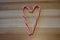 Peppermint flavored candy cane treats in a heart shape c on a wooden board