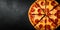 pepperoni pizza on black slate background with copy space