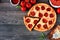 Pepperoni pizza with cut slices, top view corner border against a wood background