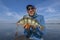 Perch fishing. Fisherman holds perch fish at lake