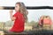 Perching girl watching over working combine harvester