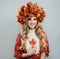 Perfect autumn woman in bright fall leaves crown holding red maple leaf