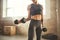 Perfect biceps. Young athletic woman with tattoo on her hand in sportswear exercising with dumbbells while standing in