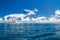 Perfect blue sea view with white boat on tropical sea, clouds and blue sky. Idyllic seascape