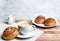 Perfect breakfast of a homemade cinnamon buns, coffee and glass milk jug on wooden table. Rustic style.