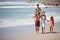 The perfect family getaway. a family walking along the beach.