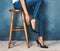 The perfect fit. Studio shot of an unidentifiable young woman trying on a pair of high heels against a blue background.