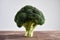 Perfect fresh broccoli on light wooden background stands as a tree. Concept of healthy food and nutrition.