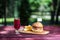 The perfect meat burger with crisps and fresh cold lemonade. On the cutting board, and green summer background.