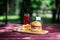 The perfect meat burger with crisps and fresh cold lemonade. On the cutting board, and green summer background.