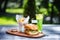 Perfect meat burger with french fries and fresh cold lemonade. On the cutting board, and green summer background.