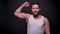 Perfect muscular arm of healthy strong caucasian man with beard and long black hair, who is standing and looking at