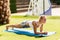 Perfect plank. Full-length side view of young beautiful woman in sportswear doing plank while standing on the greed lawn