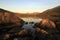 Perfect reflection of mountains and rocks glowing with the sunrise in a lake