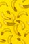 Perfect ripe bananas on yellow surface. From above creative composition of sparkling bananas