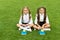 Perfect school children sit on grass with books, having good time concept