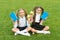 Perfect school children sit on grass with books, school time concept