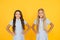 Perfect schoolgirls. Schoolgirls vintage simple style outfit. Cheerful schoolgirls yellow background. Little girls