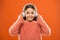 Perfect sound stereo headphones. Girl cute little child wear headphones listen music. Kid listen music orange background