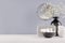 Perfect stylish decoration for home - black glass vase with small flowers, mirror, female silver cosmetic, bowl sponges.