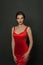 Perfect stylish model woman in red silky dress on black