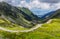 Perfect sunny landscape. Fantastic mountain valley. View on beautiful mountain road at sunrise in summer.  Highway in european