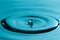 Perfect water drop splashing into smooth water causing ripples