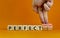 Perfectionism symbol. Concept words Perfect or Perfectionism beautiful wooden blocks. Beautiful orange background. Businessman