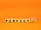 Perfectionism symbol. Concept words Perfect or Perfectionism beautiful wooden blocks. Beautiful orange table orange background.