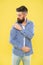 Perfectly imperfect. Fashion man dusting specks off his sleeve on yellow background. Bearded man in hipster fashion