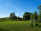 Perfectly mowed lawn and blue sky on a sunny summer day. On the side you can see a target for weapons and a fence