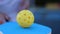 Perforated ball for pickleball spinning on a paddle racquet in slow motion