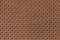 Perforated brown leather texture background, closeup. Bronze backdrop from wrinkle skin