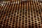 Perforated brown rusty iron sheet texture. Surface with depth of field, abstract mesh. Horizontal grunge background