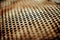 Perforated brown rusty iron sheet texture. Surface with depth of field, industrial mesh. Horizontal light background