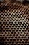 Perforated brown rusty iron sheet texture. Surface with depth of field, industrial mesh. Vertical background