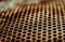 Perforated brown rusty iron sheet texture. Surface of industrial mesh with depth of field. Horizontal corrosion background