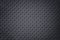 Perforated dark gray leather texture background, closeup. Black backdrop from wrinkle skin