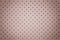 Perforated light pink leather texture background, closeup. Rose backdrop from wrinkle skin