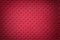 Perforated red leather texture background, closeup. Dark backdrop from wrinkle skin